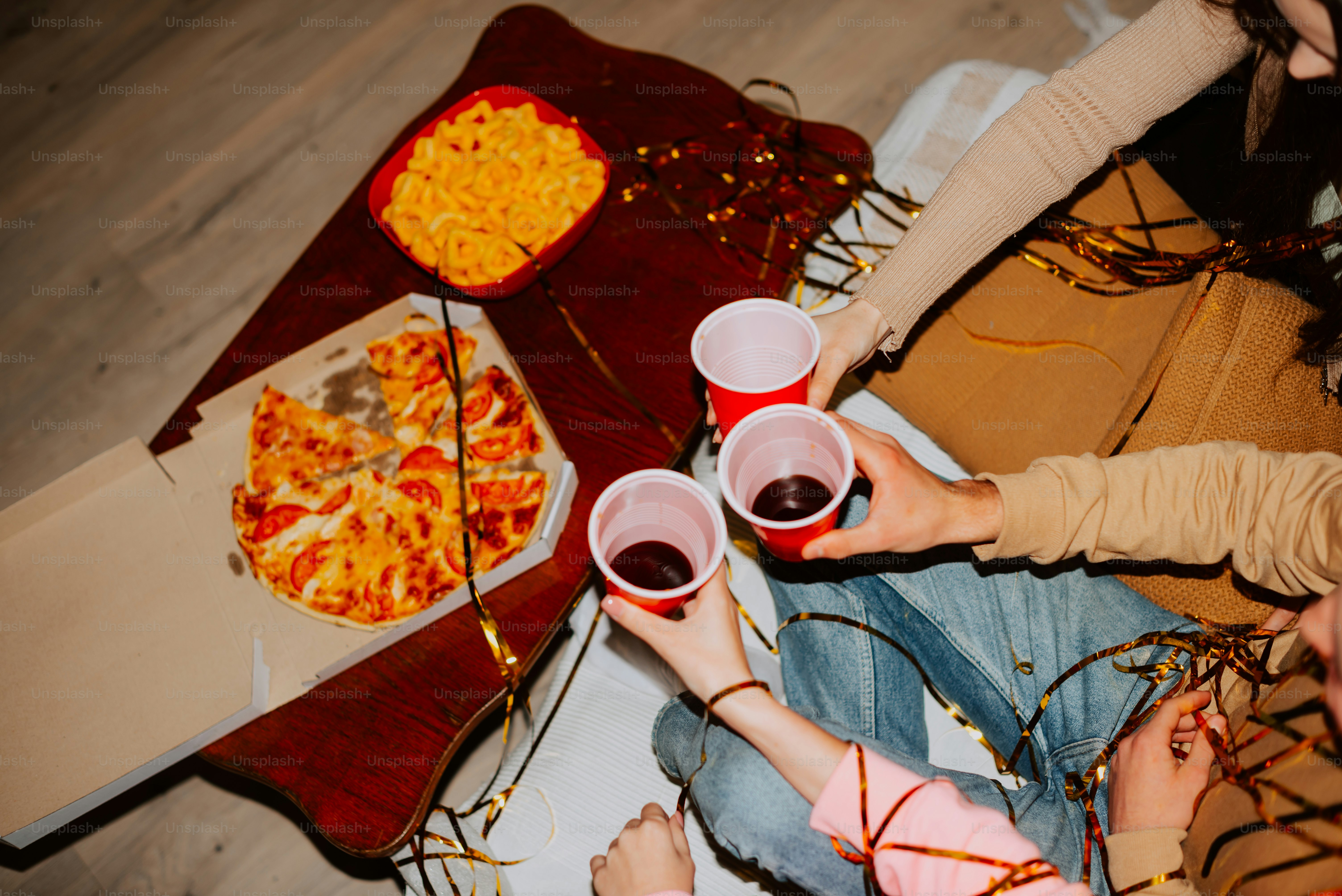a group of people sitting around a pizza on a table