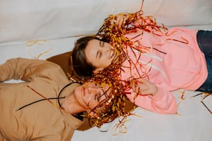 a man and a woman laying on a bed covered in confetti