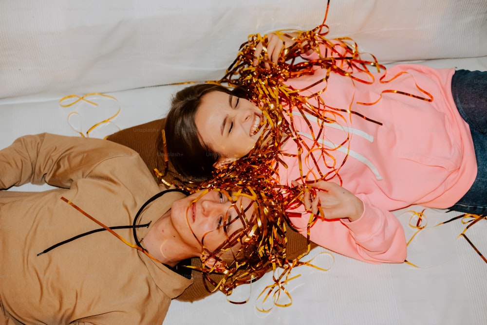 Un hombre y una mujer acostados en una cama cubierta de confeti