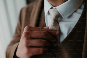 um close up de uma pessoa amarrando uma gravata