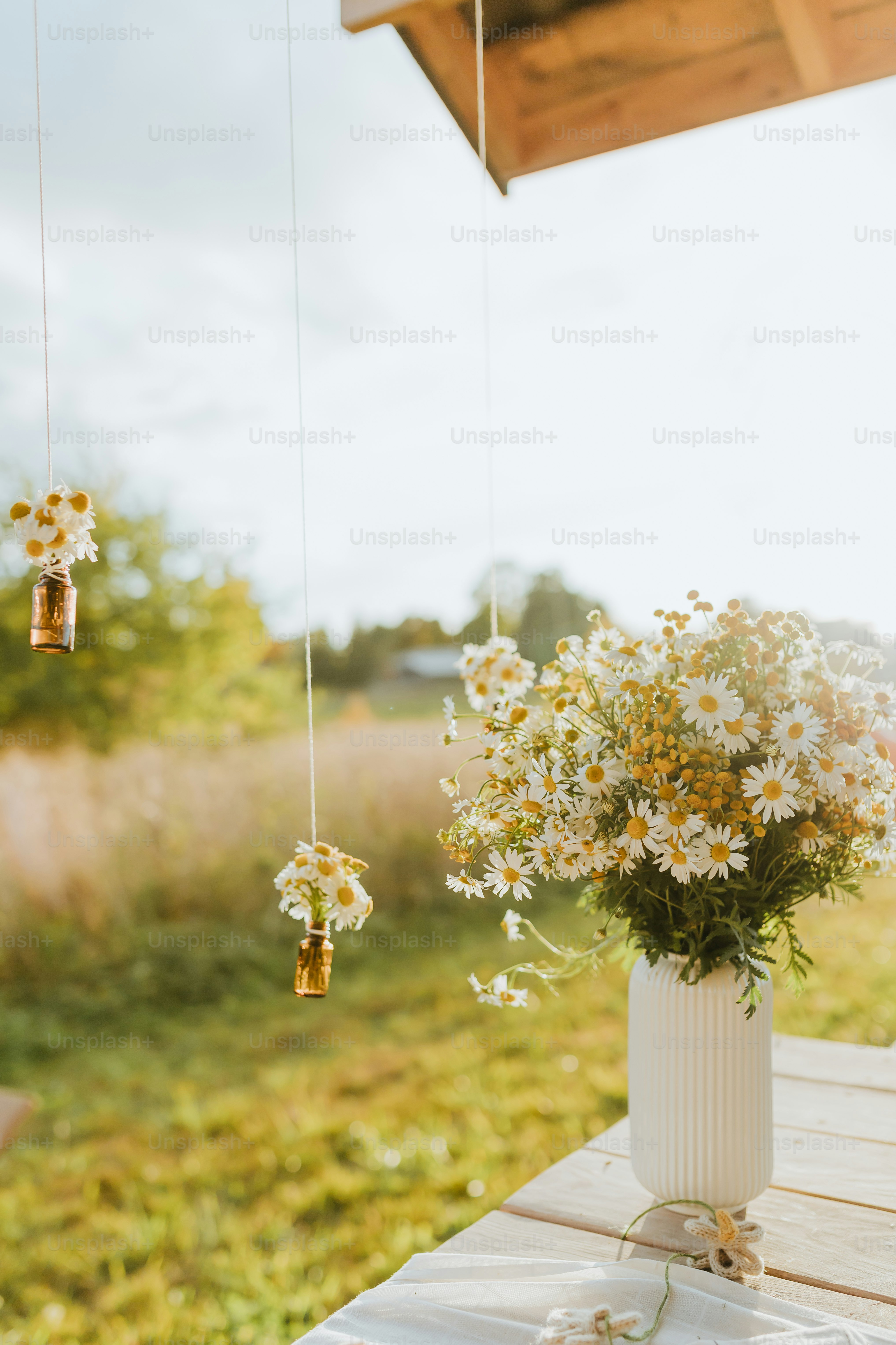 a white vase filled with flowers sitting on top of a wooden table
