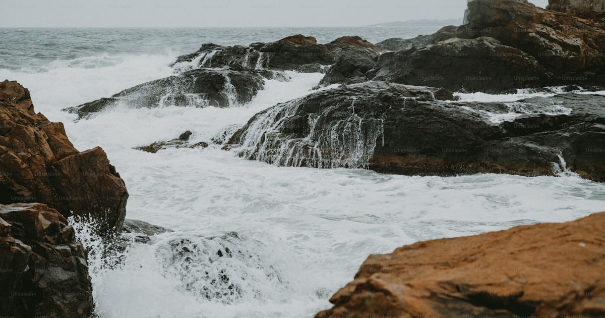 Quelques rochers qui sont dans l’eau photo – Vagues s’écrasant sur les ...