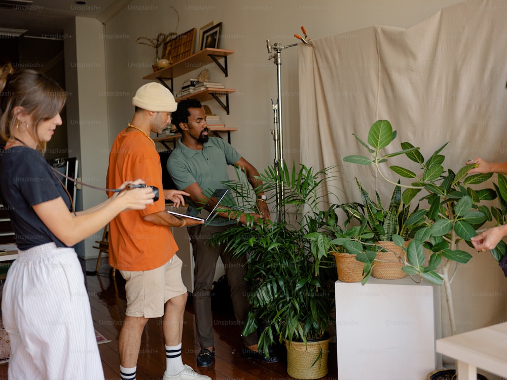 a group of people standing around a plant