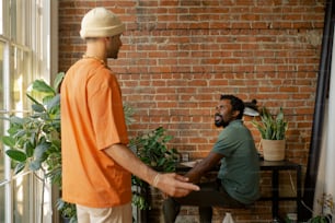 a man in an orange shirt is talking to another man