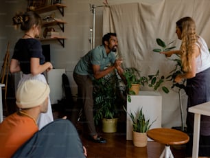 a group of people in a room with plants