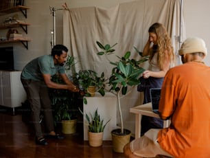 a man and a woman are looking at a potted plant
