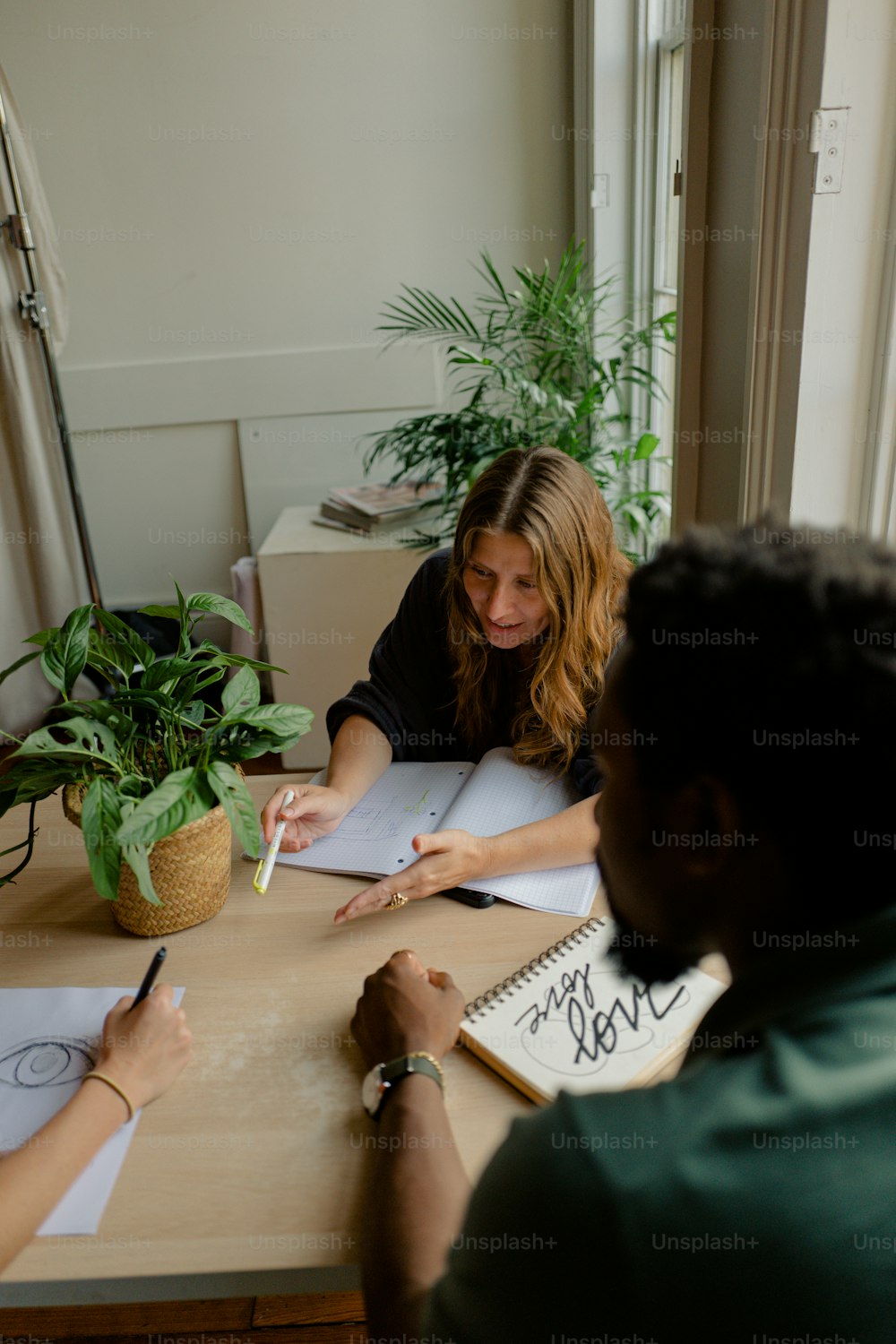 a man and a woman sitting at a table writing