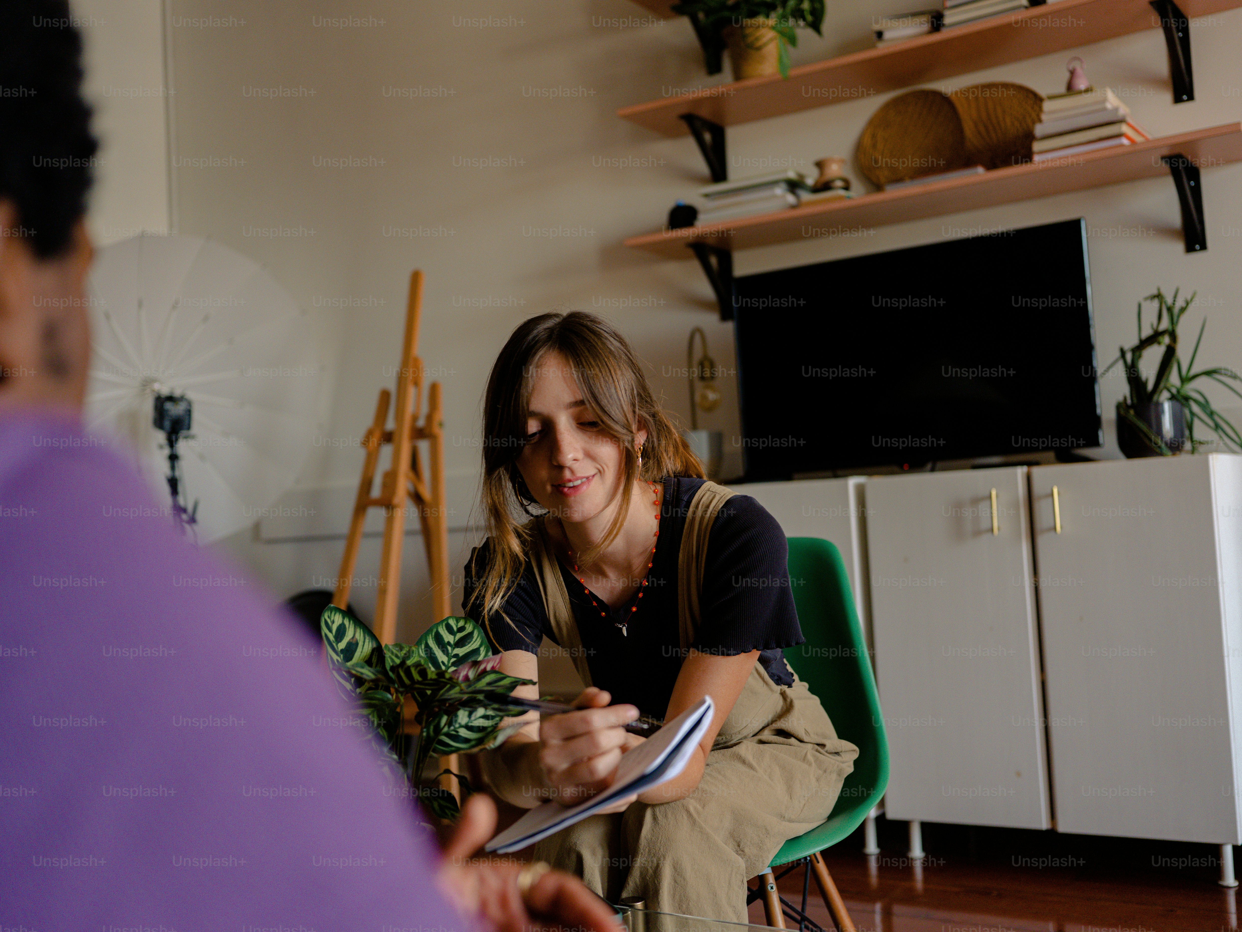 a woman sitting in a chair writing on a piece of paper