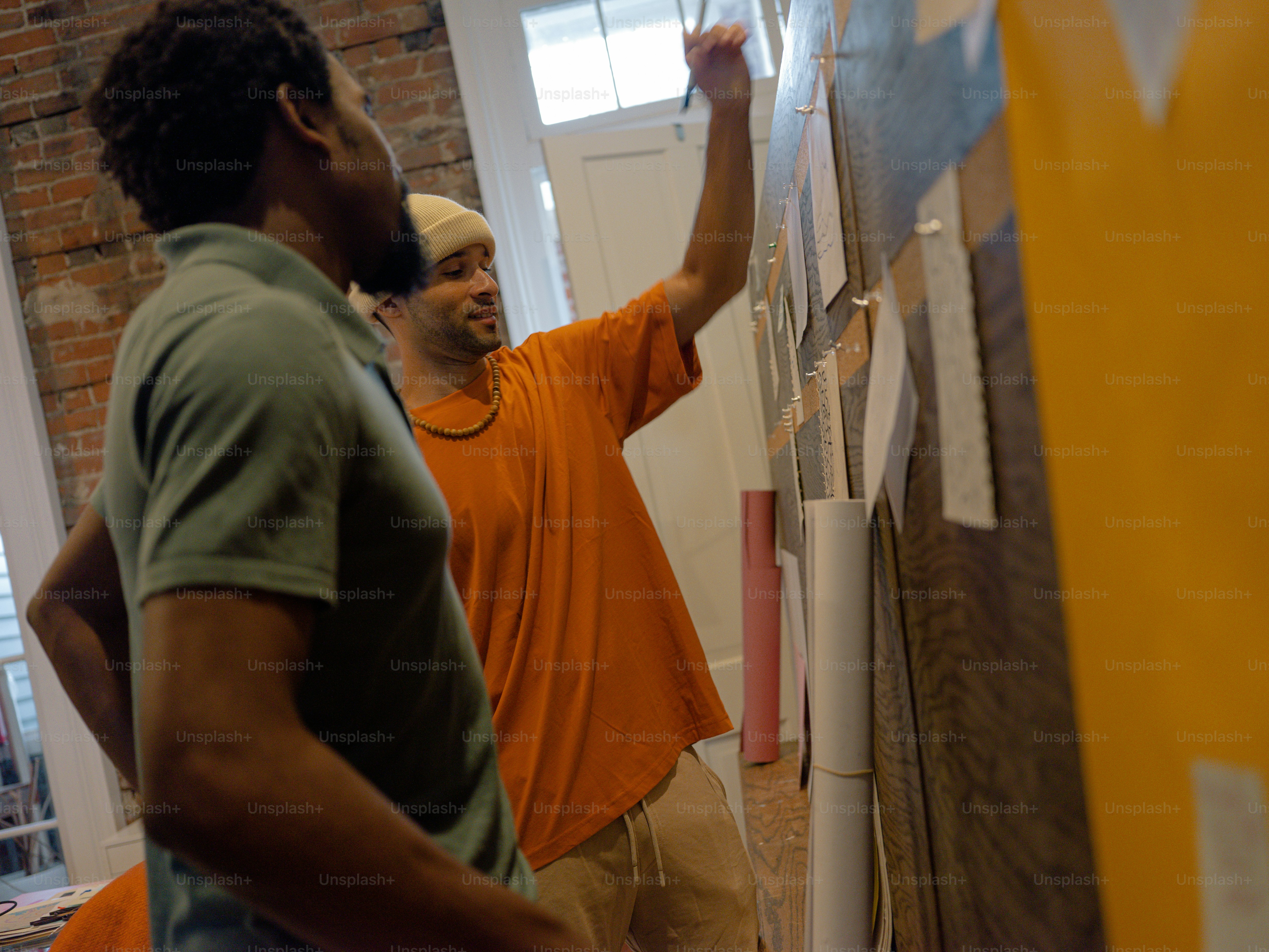 a couple of men standing next to each other near a wall
