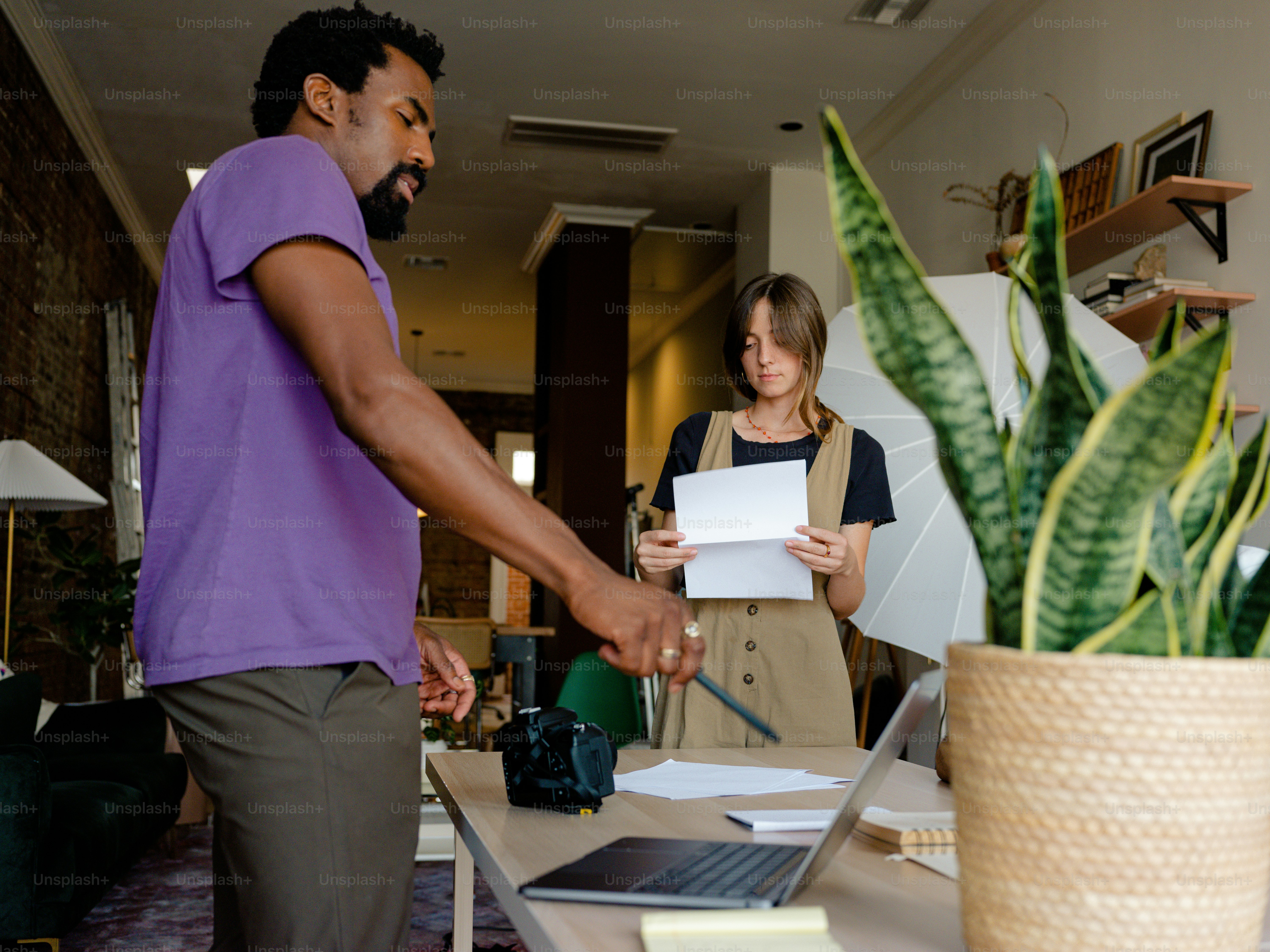 Un homme et une femme debout devant un ordinateur portable