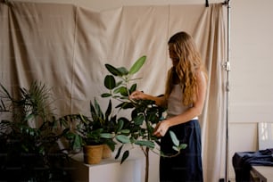 a woman standing in front of a potted plant