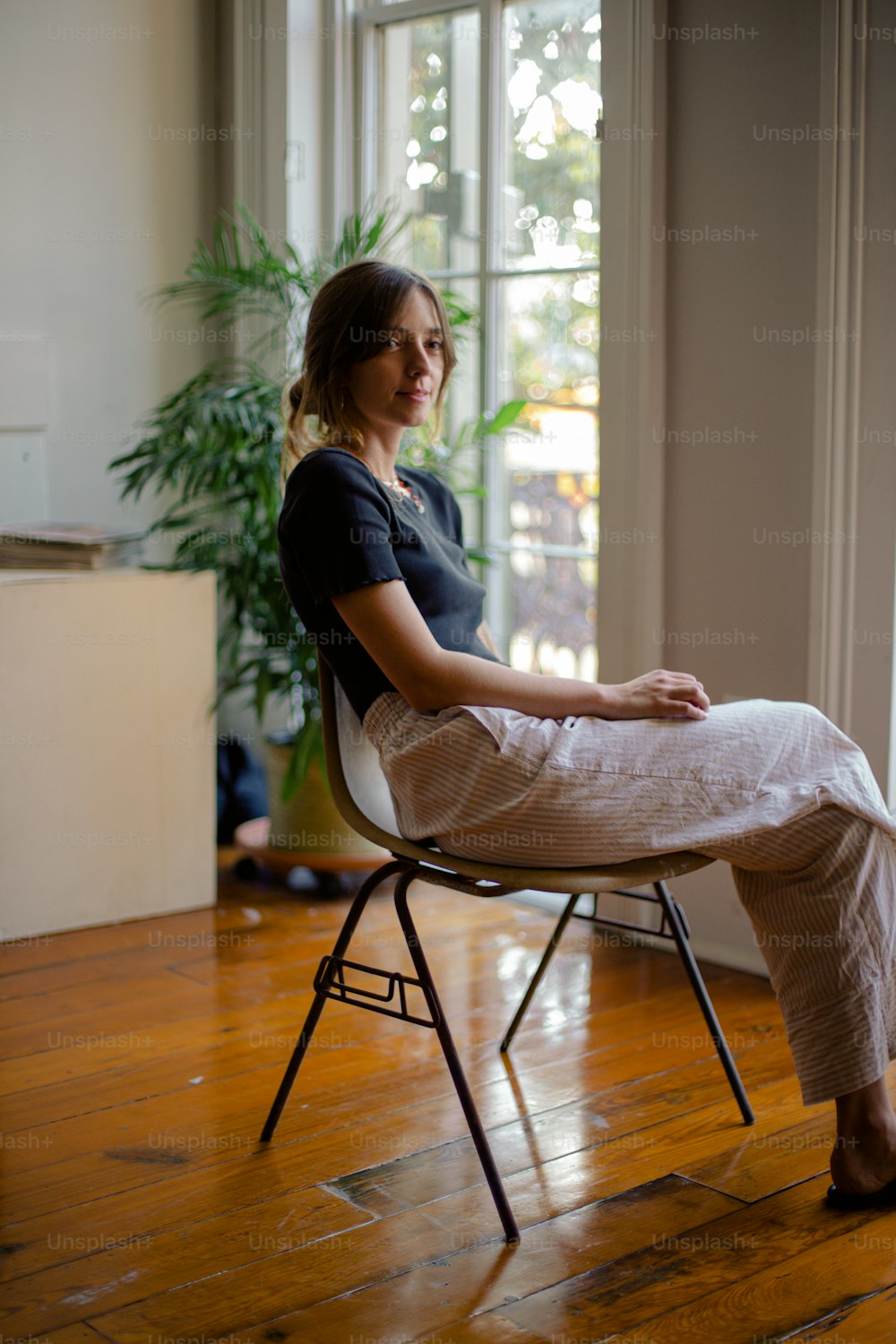 a woman sitting in a chair in front of a window