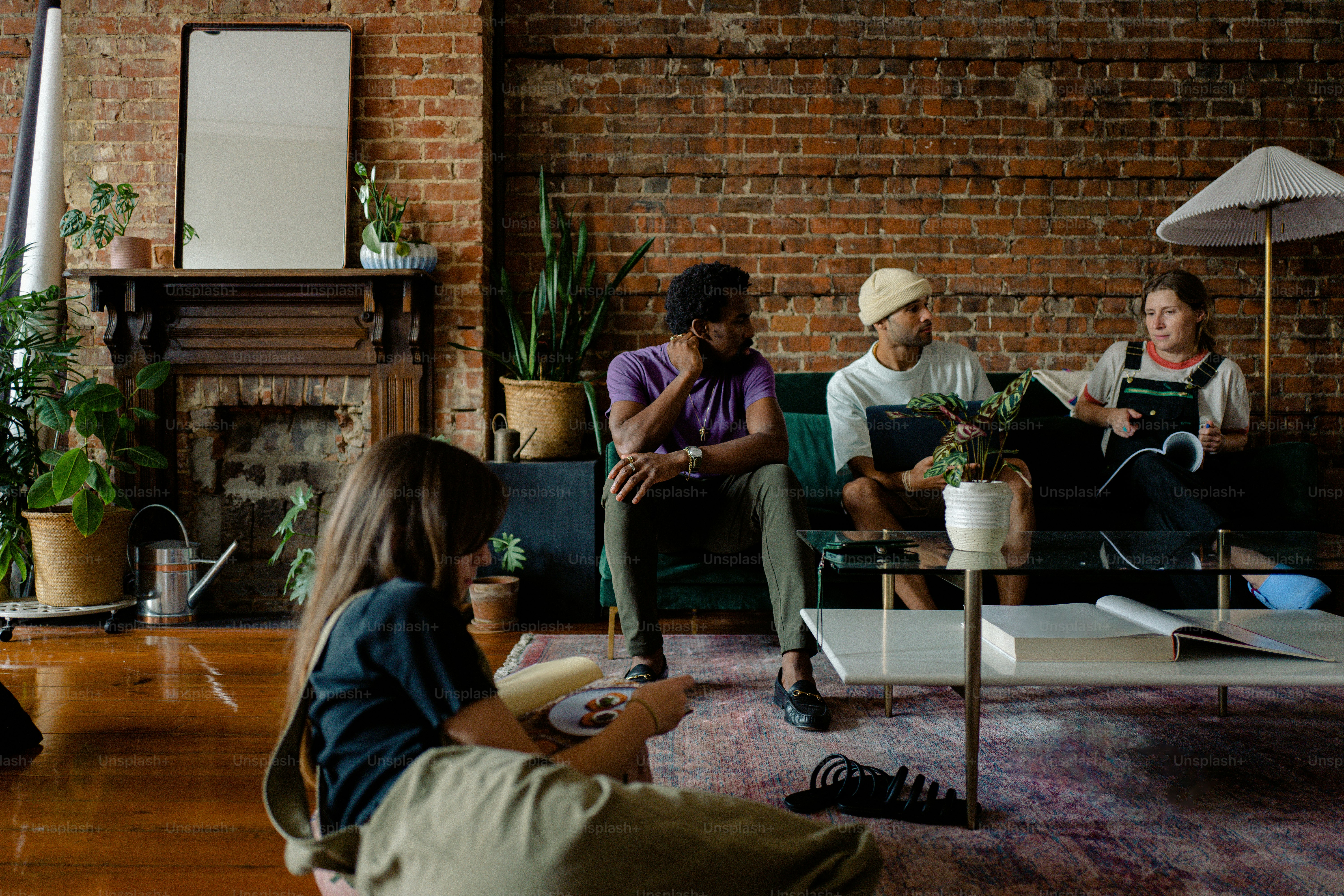 A group of people sitting around a living room photo – Sofa Image on ...
