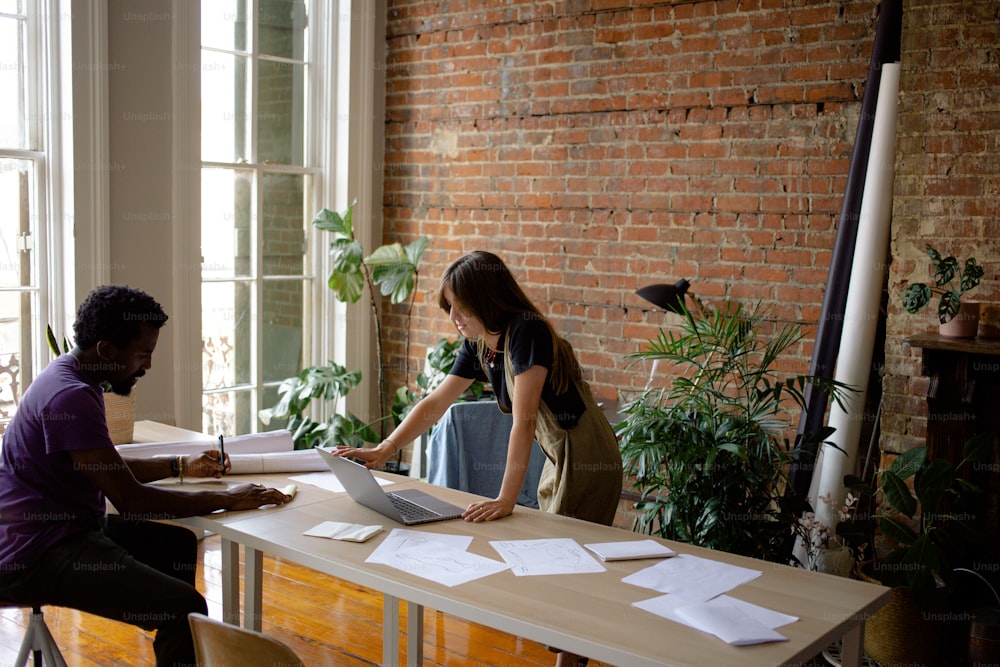 a man and a woman sitting at a table with papers