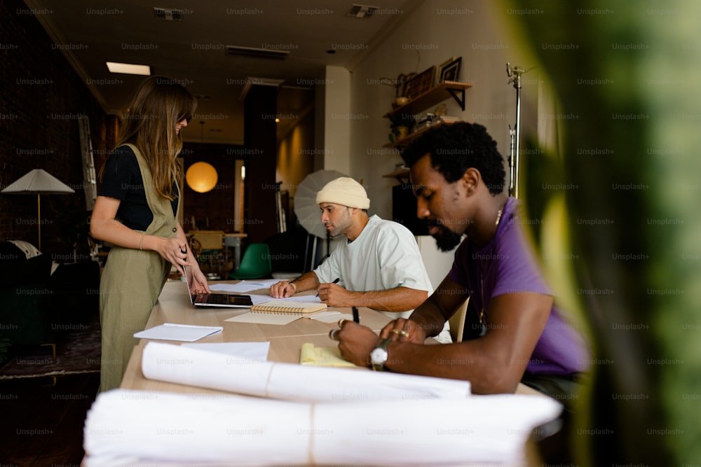 a group of people sitting around a table with papers