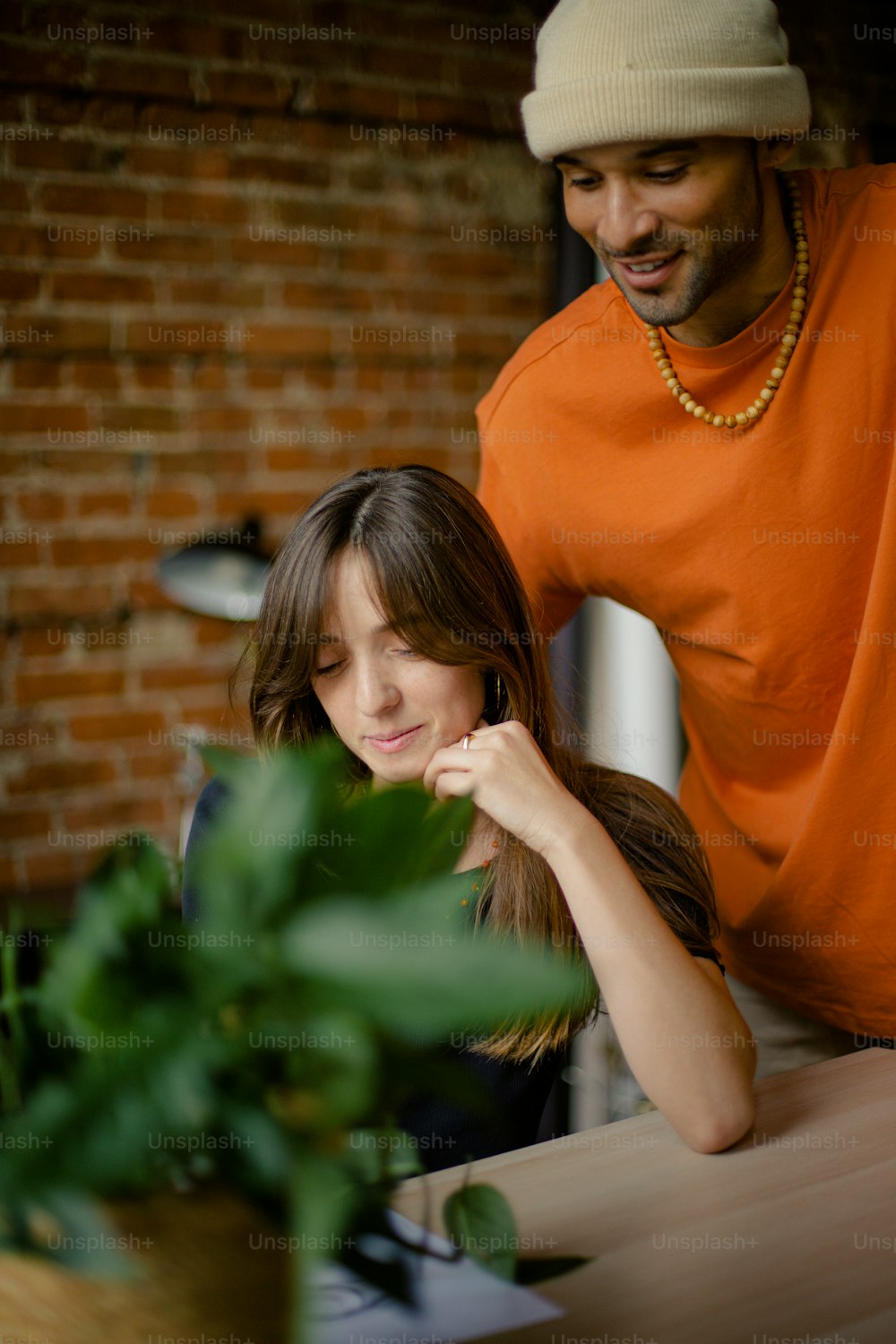 a man standing next to a woman near a plant