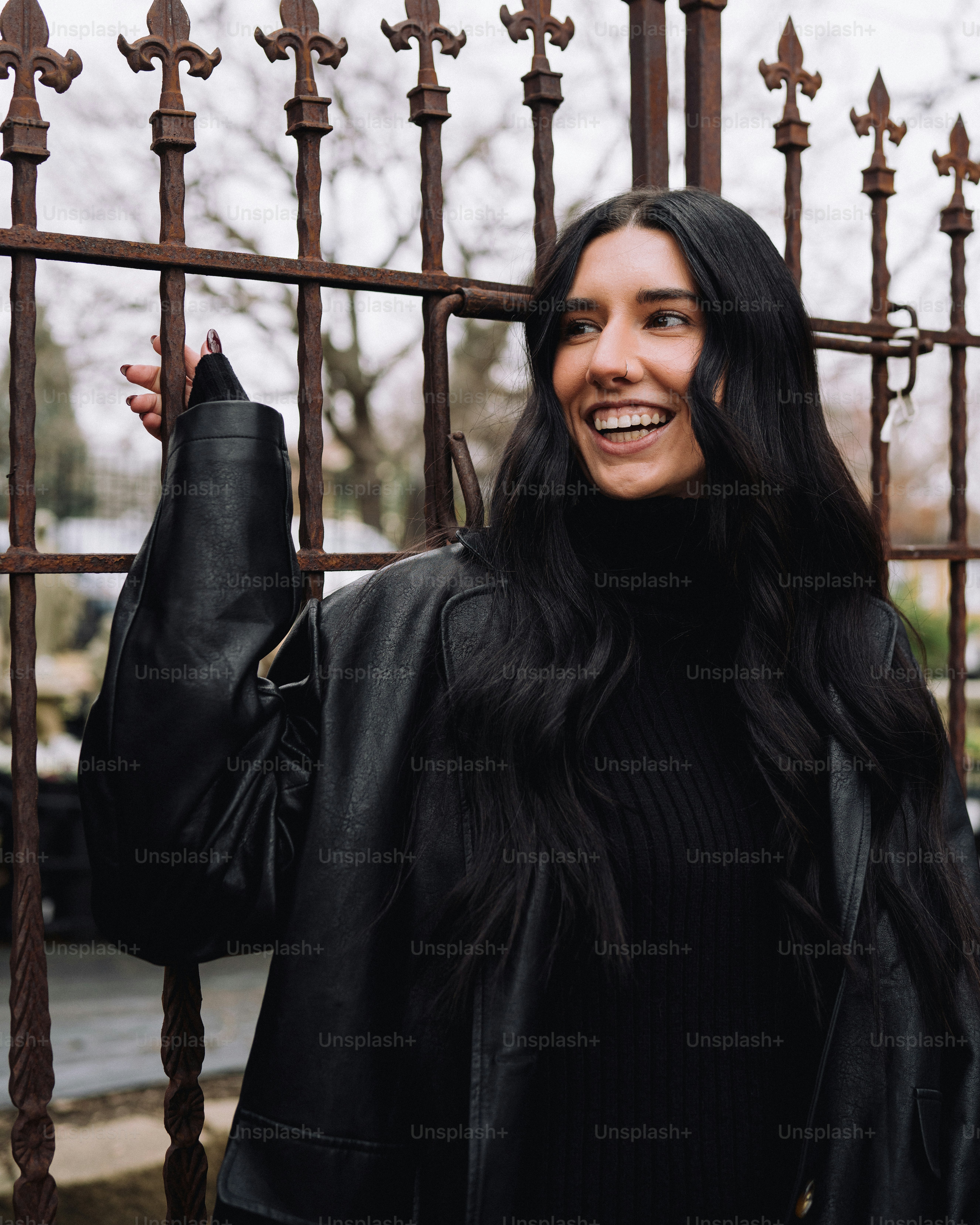 a woman standing in front of a metal fence