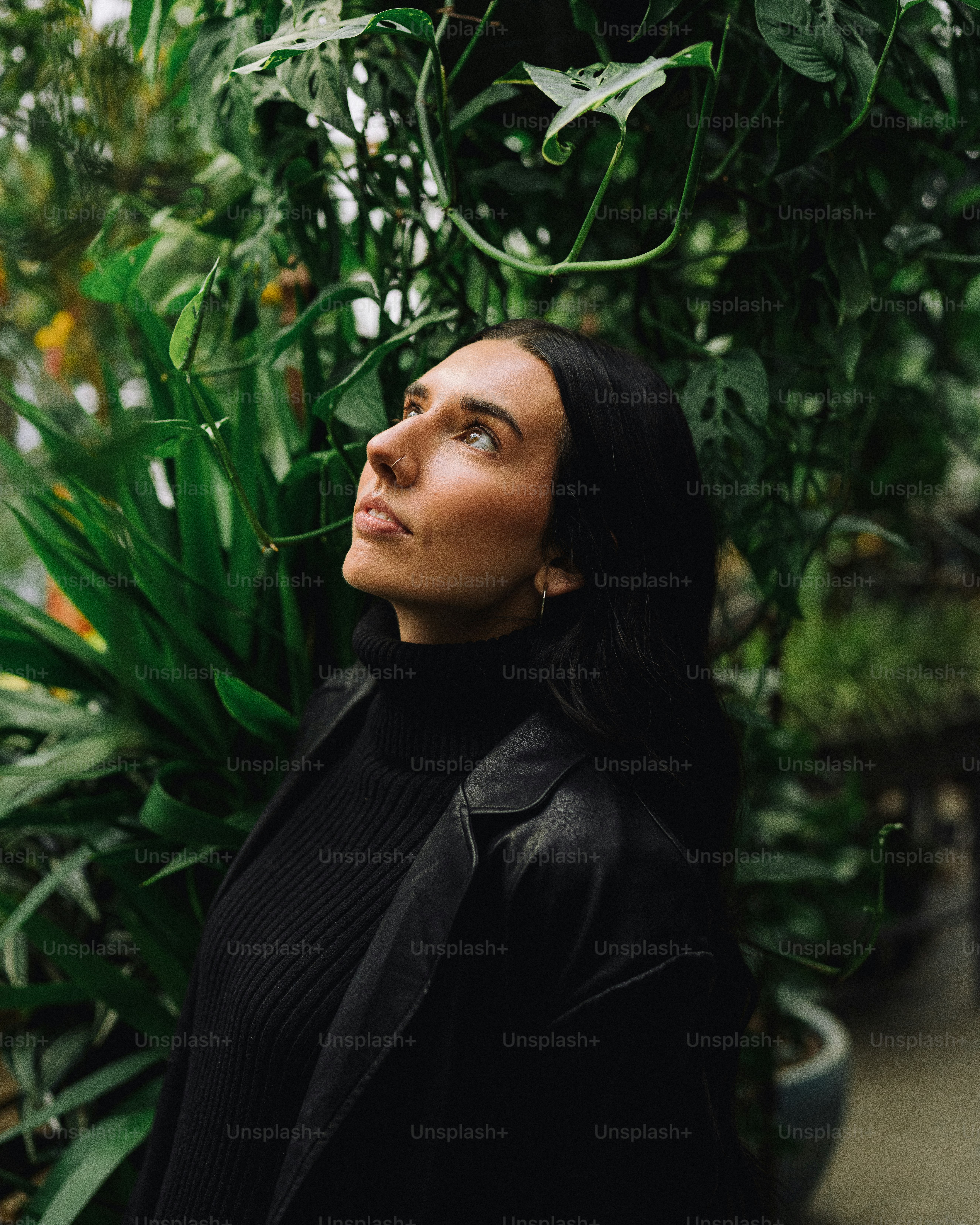a woman standing in front of a bunch of plants