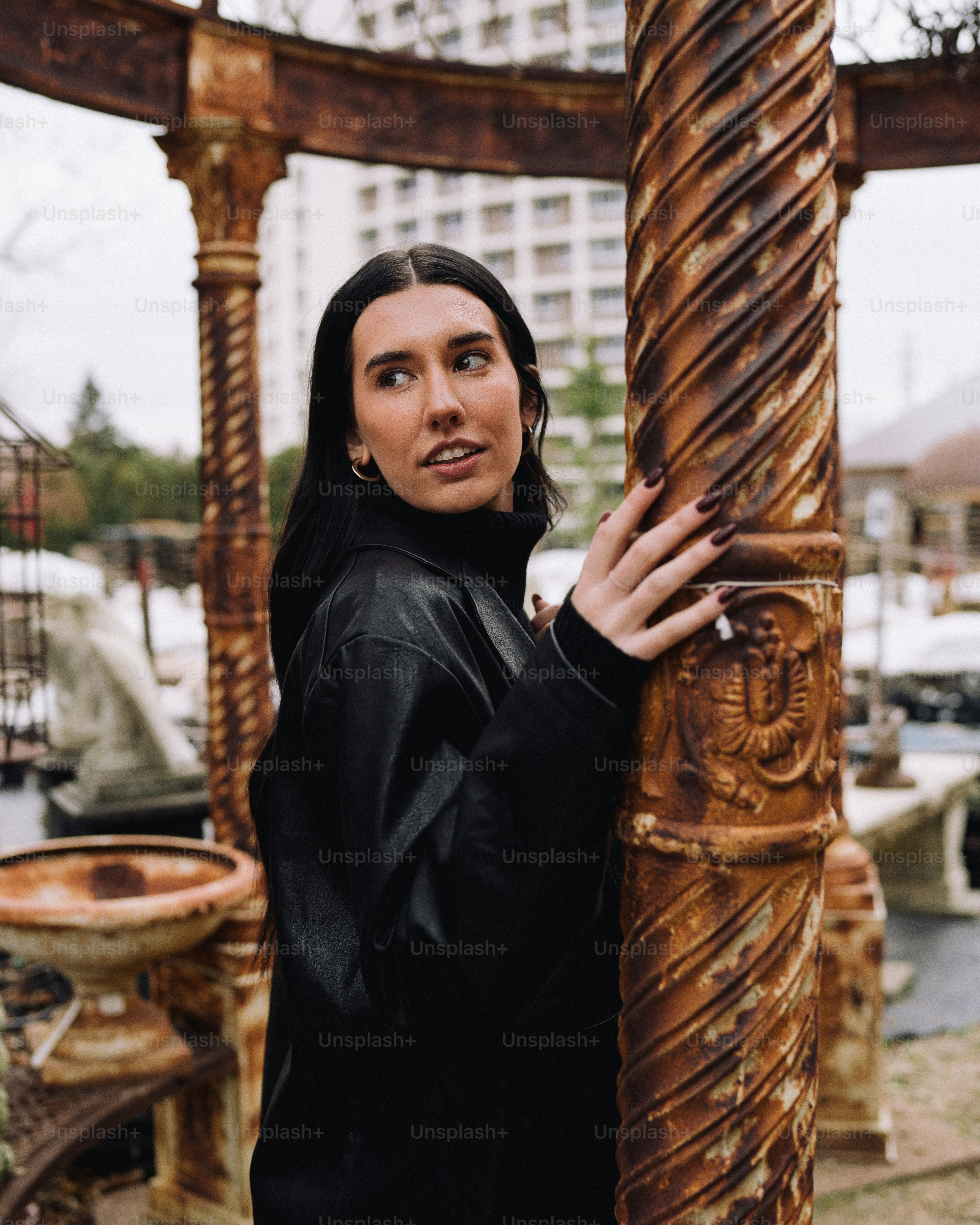 a woman standing next to a tall wooden pole