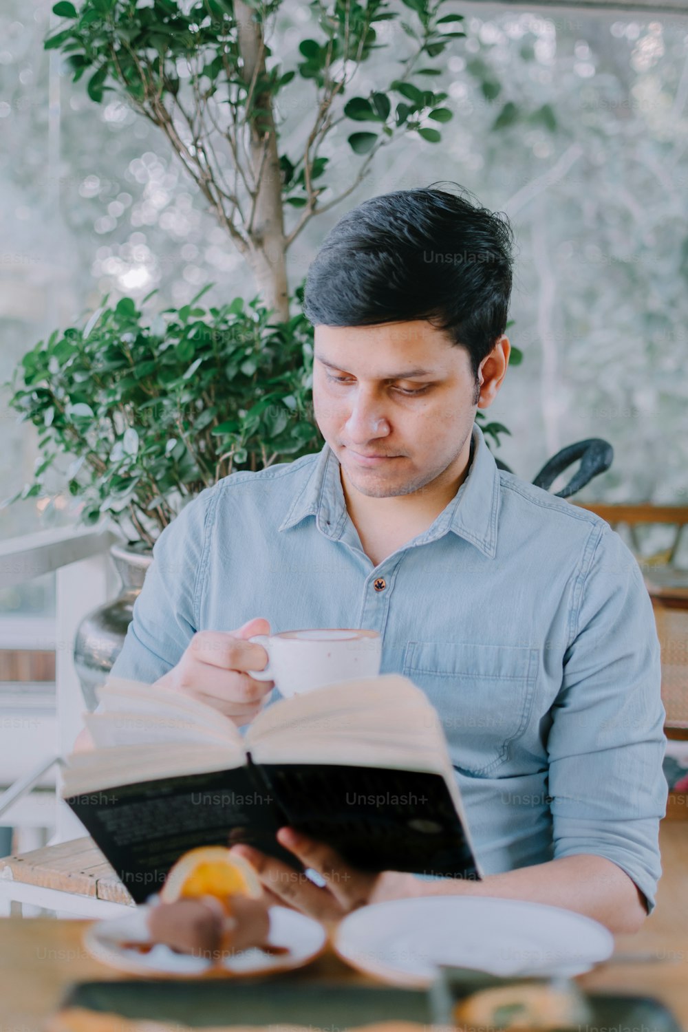 a man sitting at a table reading a book