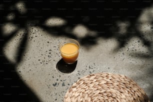 um chapéu de palha e um copo de suco de laranja