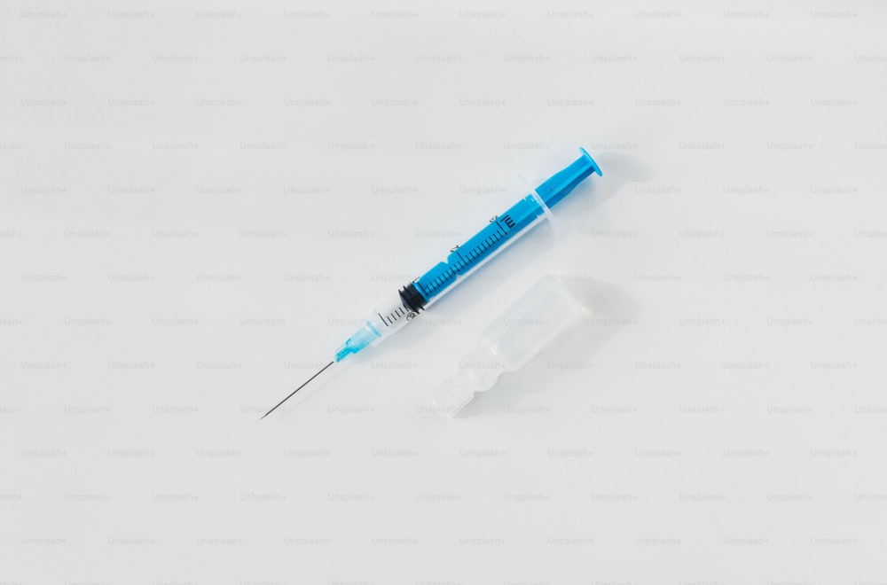 a blue and black needle and a white background
