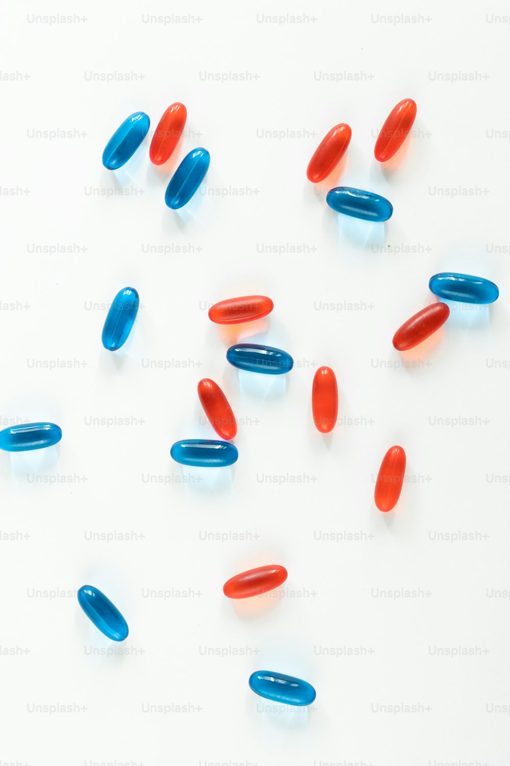 Un gruppo di pillole rosse e blu su una superficie bianca