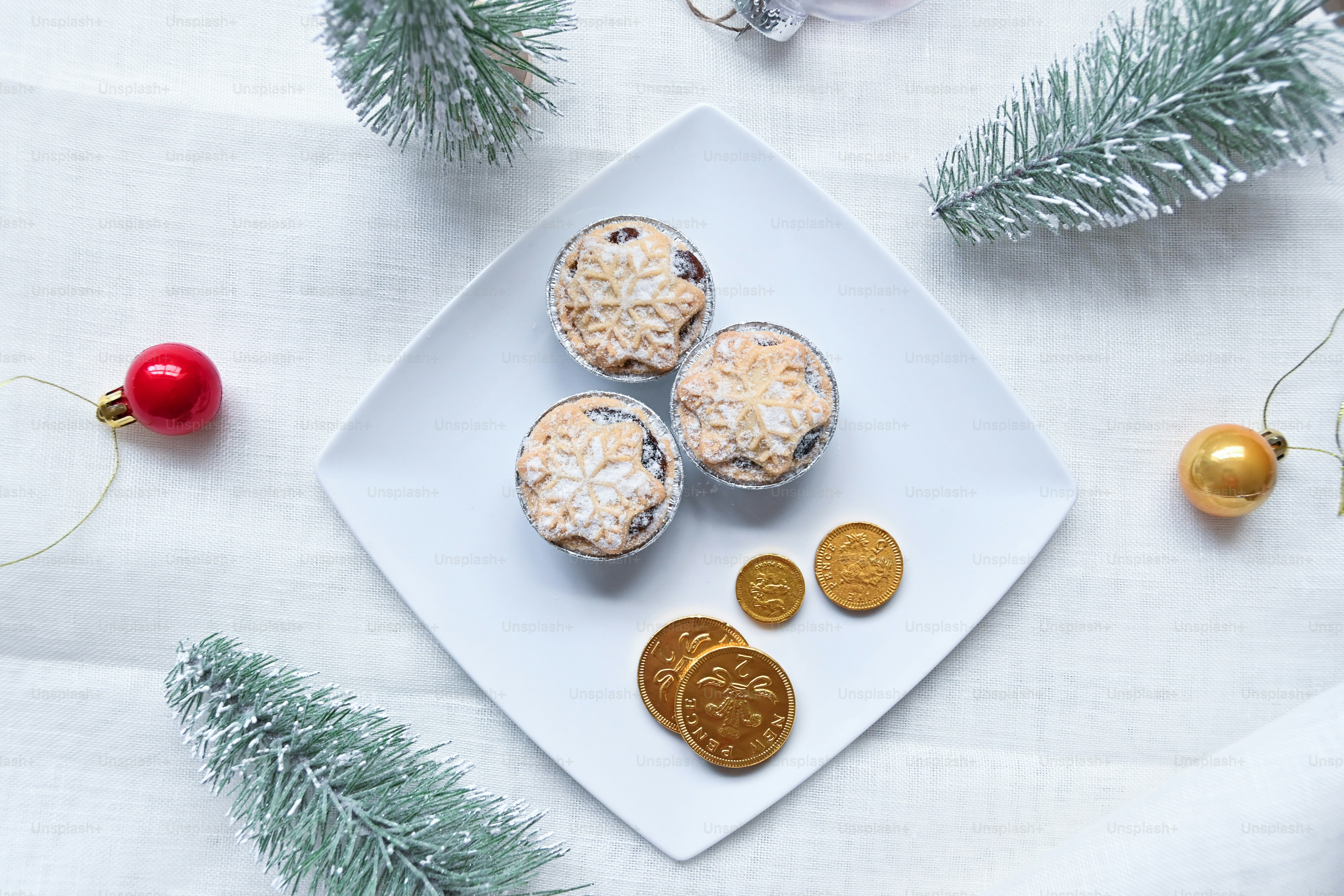 Un piatto bianco sormontato da cupcakes accanto alle decorazioni natalizie