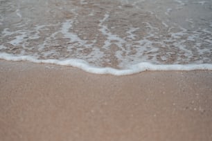 Un primer plano de una ola que entra en la playa