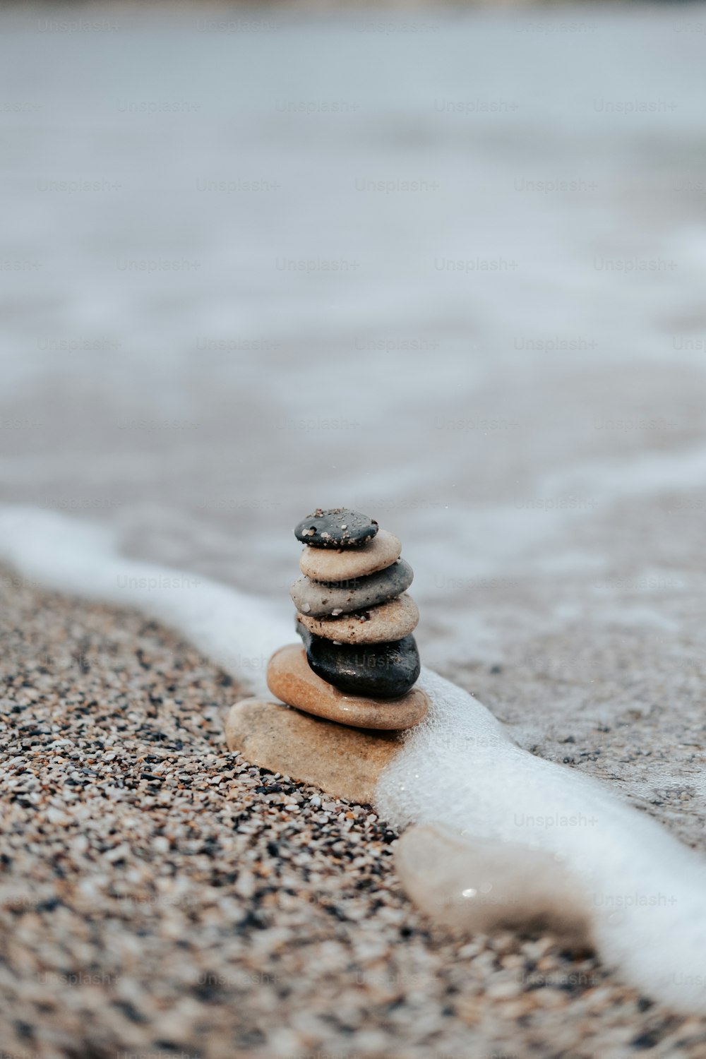a stack of rocks sitting on top of a sandy beach