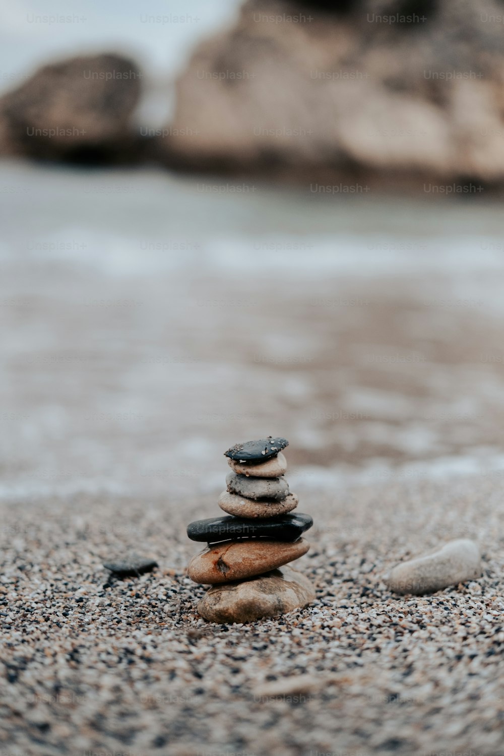 Una pila di rocce sedute sulla cima di una spiaggia sabbiosa