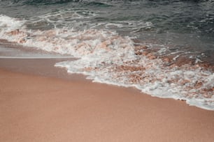 Ein Sandstrand mit Wellen, die an Land kommen