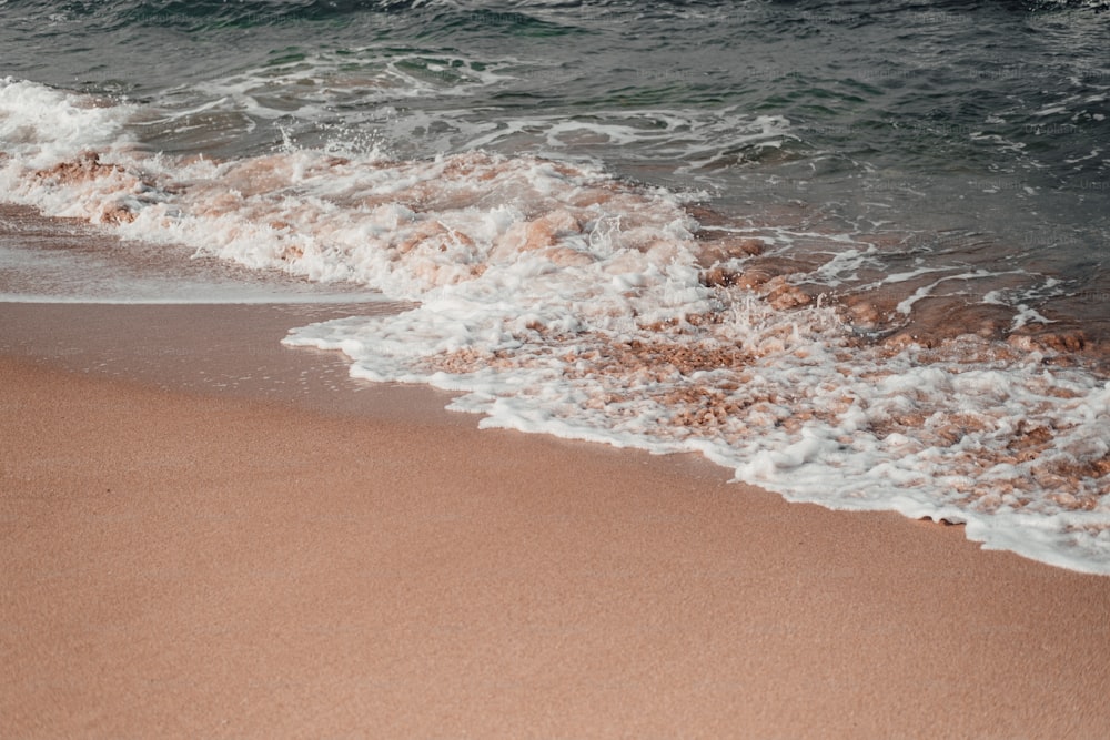 a sandy beach with waves coming in to shore