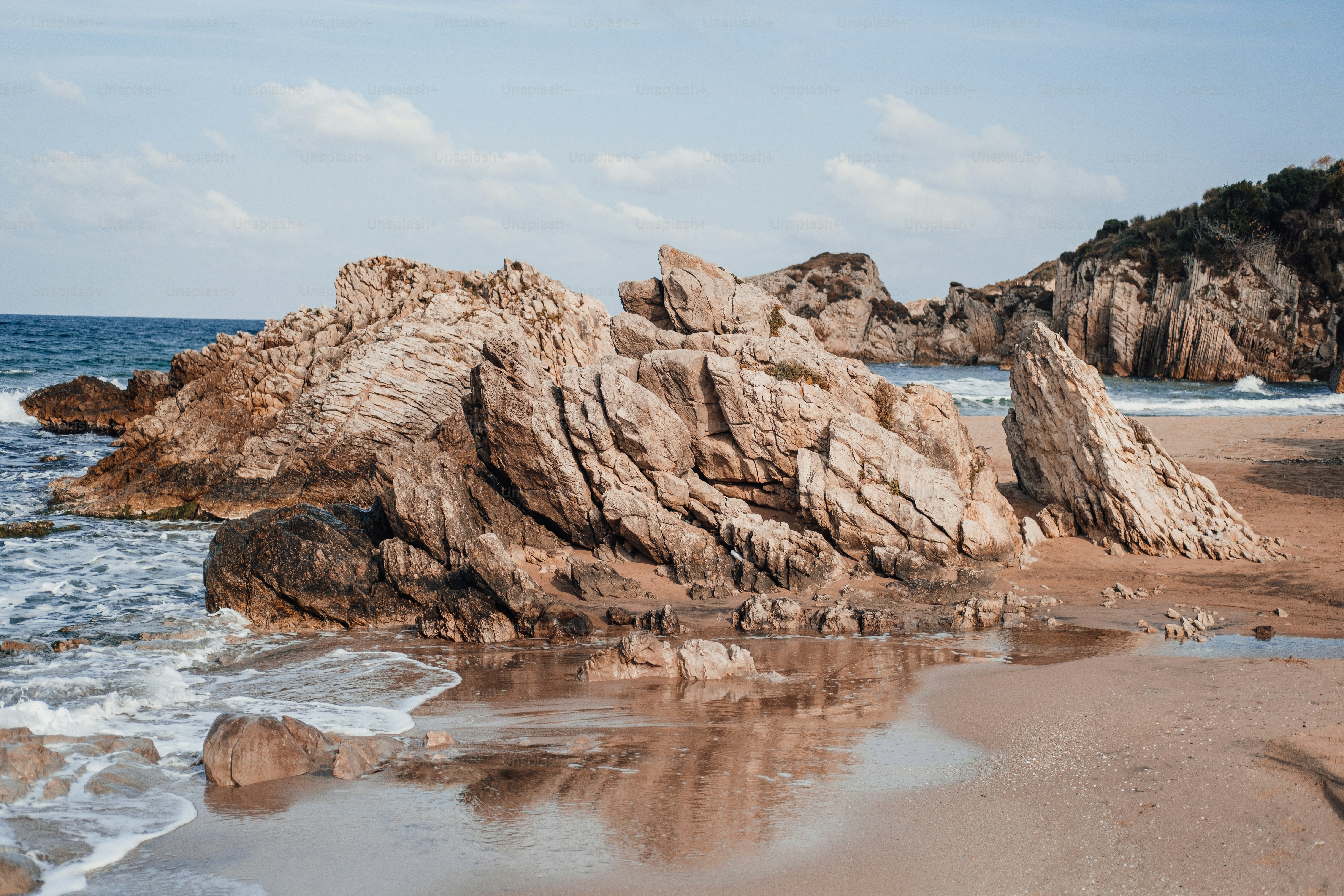 Une formation rocheuse sur une plage avec des vagues qui arrivent photo ...