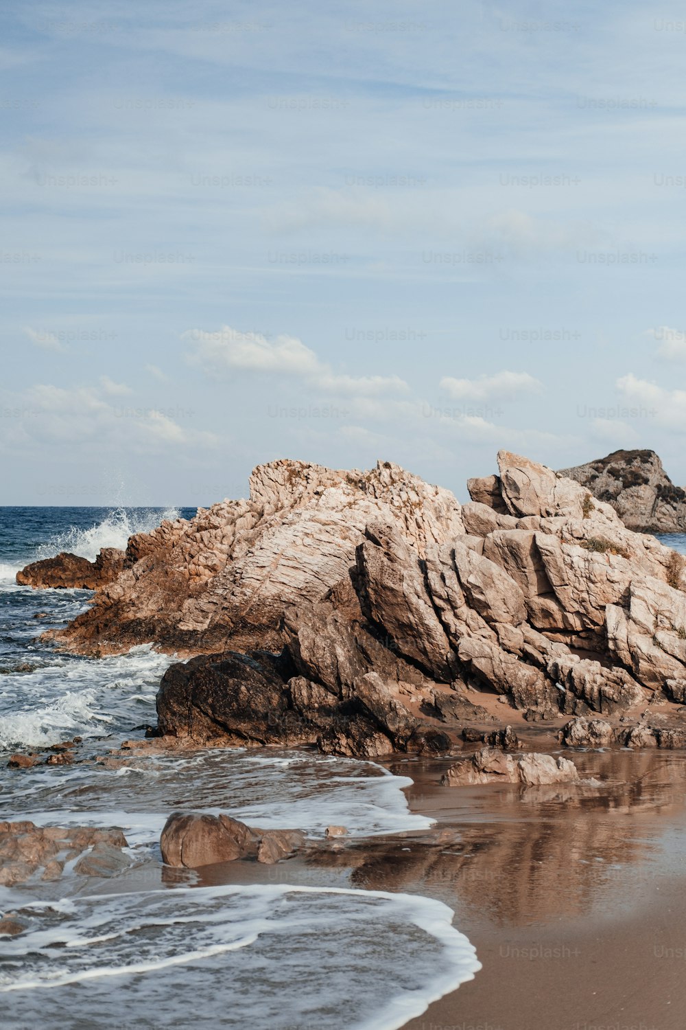 a rock formation on the beach near the ocean