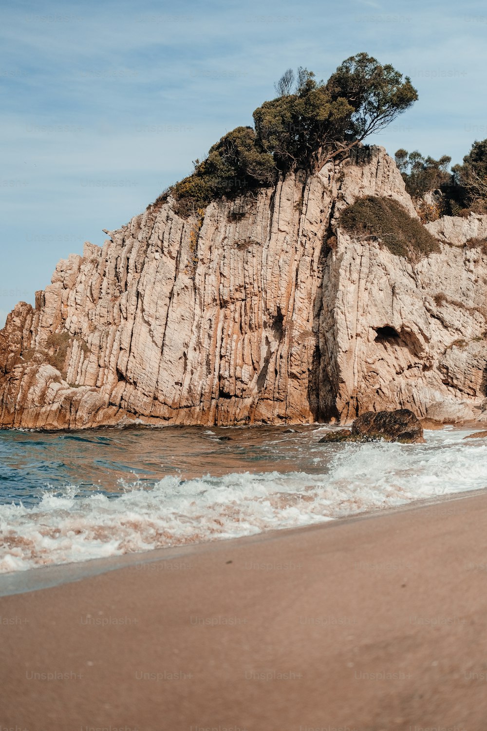 Una grande roccia affiorante su una spiaggia vicino all'oceano
