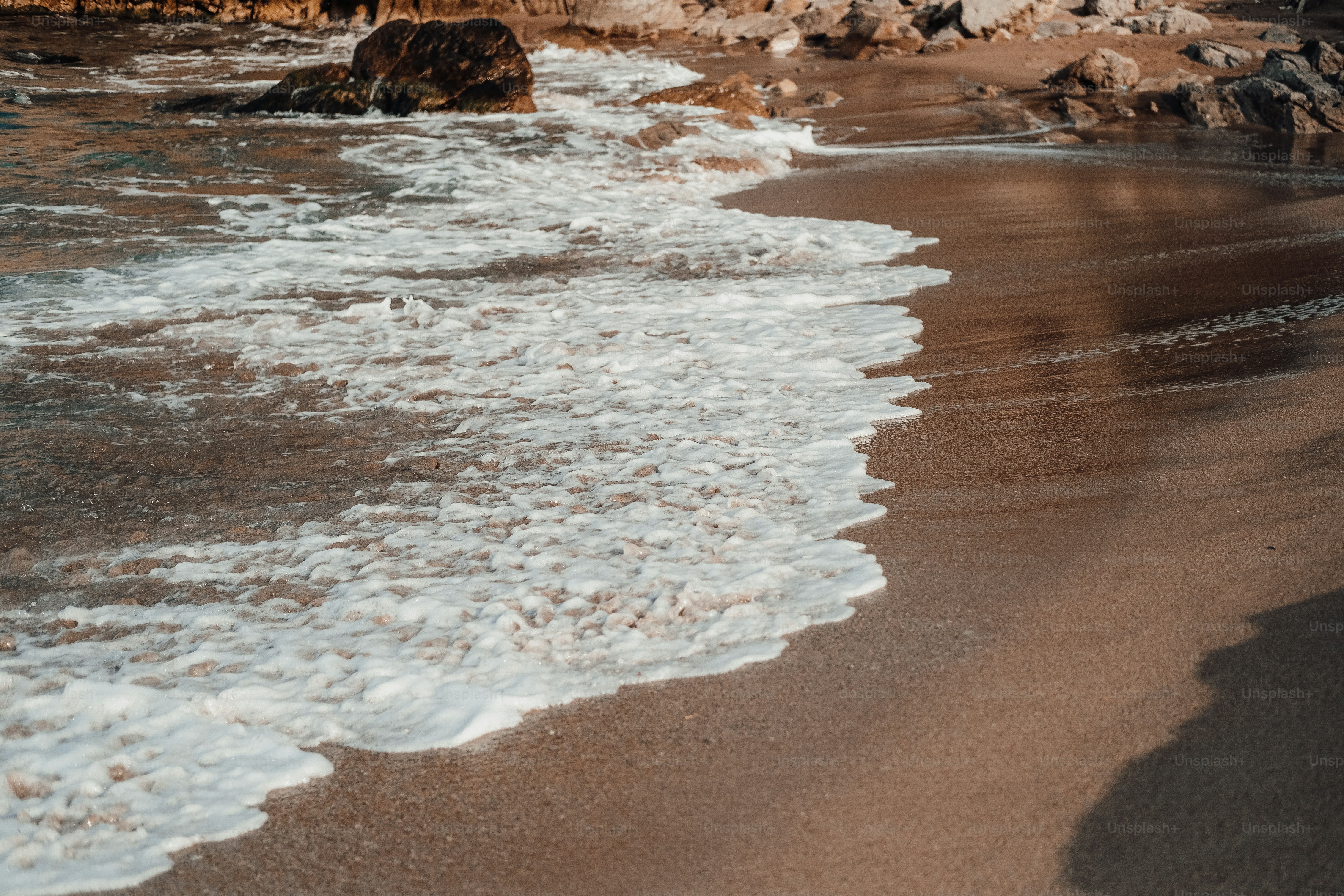 seseorang berdiri di pantai di sebelah laut