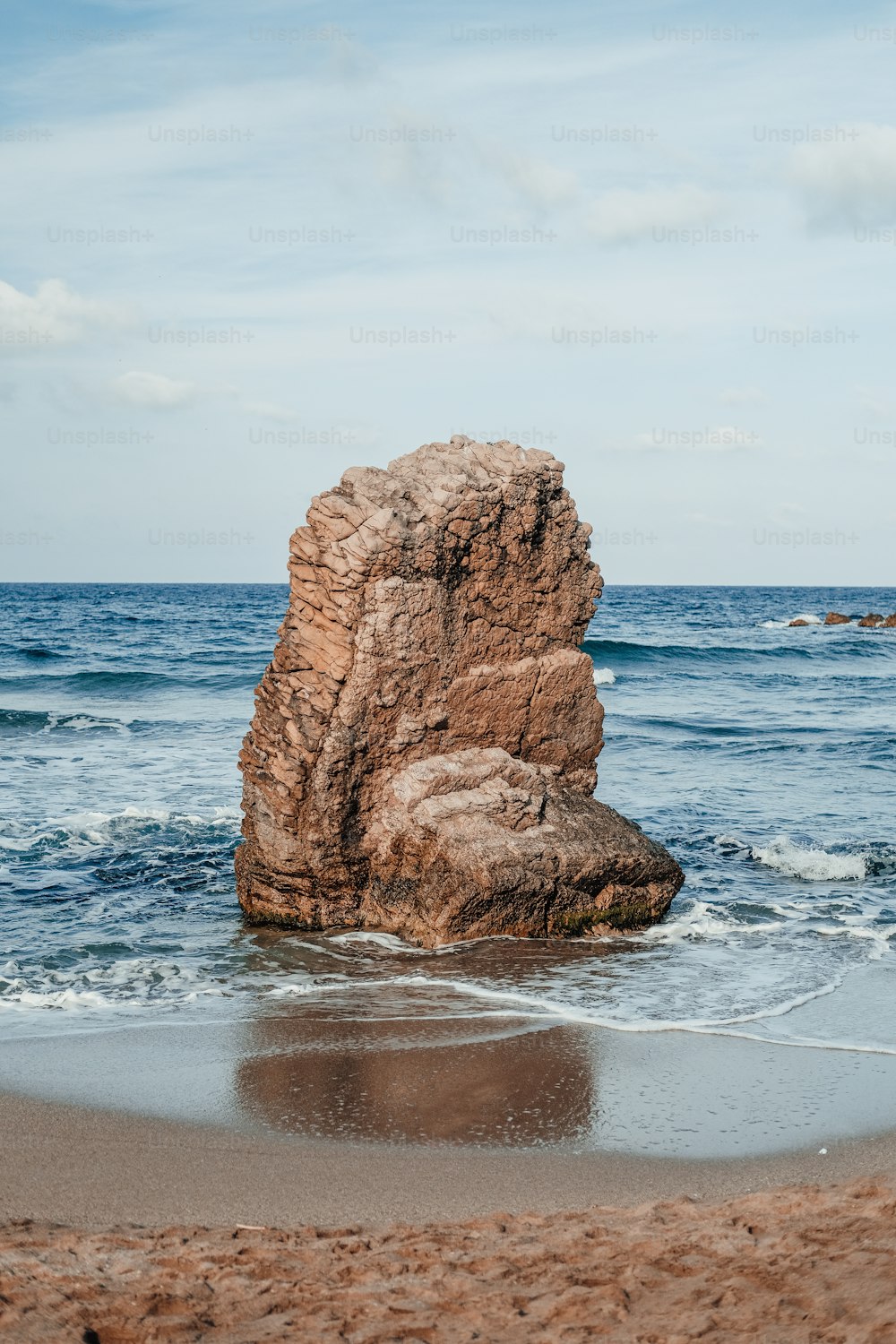 a large rock sticking out of the ocean