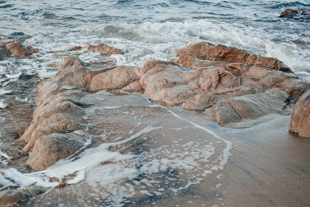 a rocky beach with waves crashing on the rocks