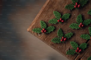 a wooden table topped with holly and red berries