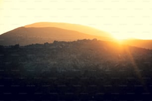 the sun is setting over a mountain range