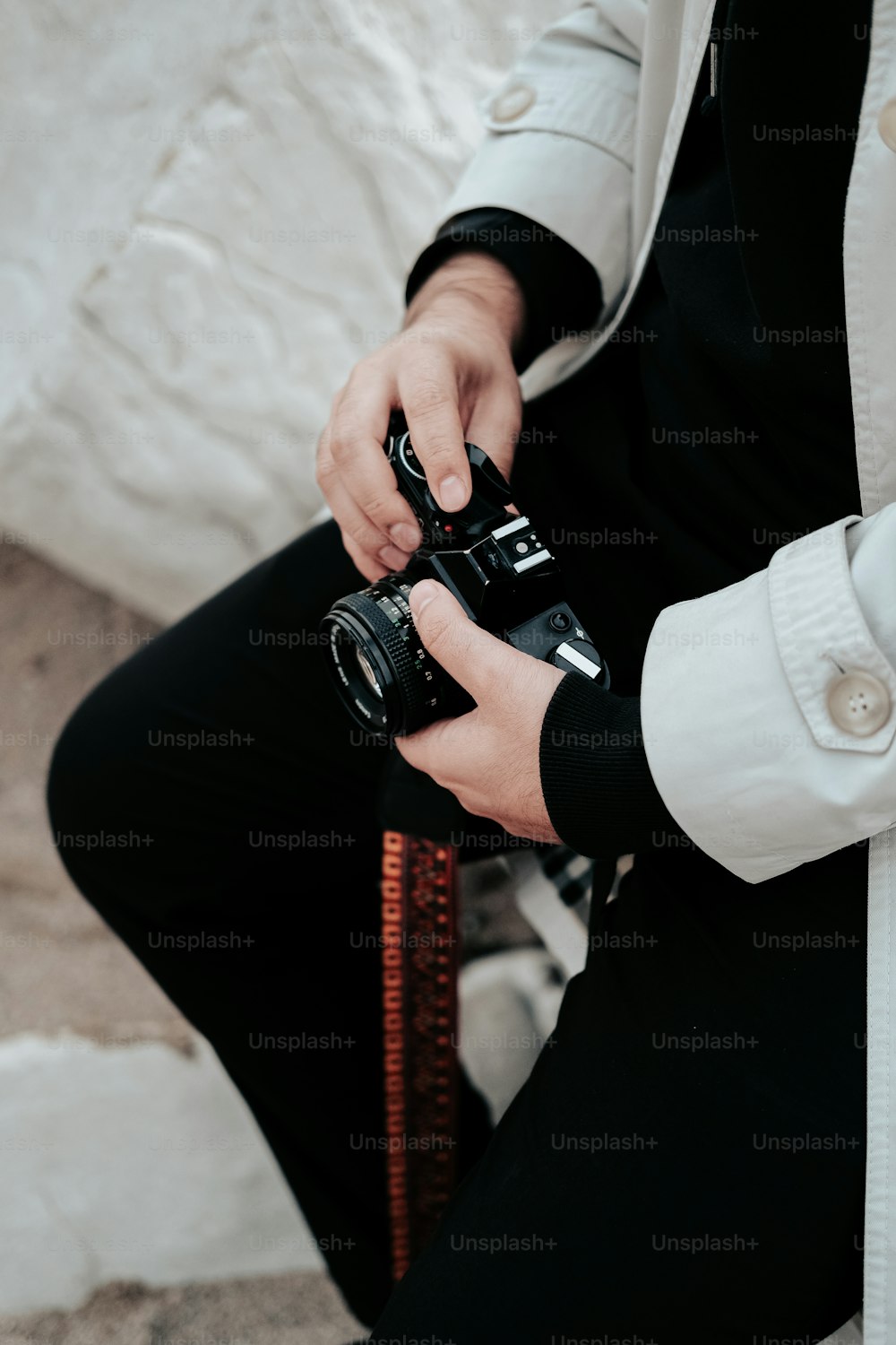 a man in a white jacket holding a camera