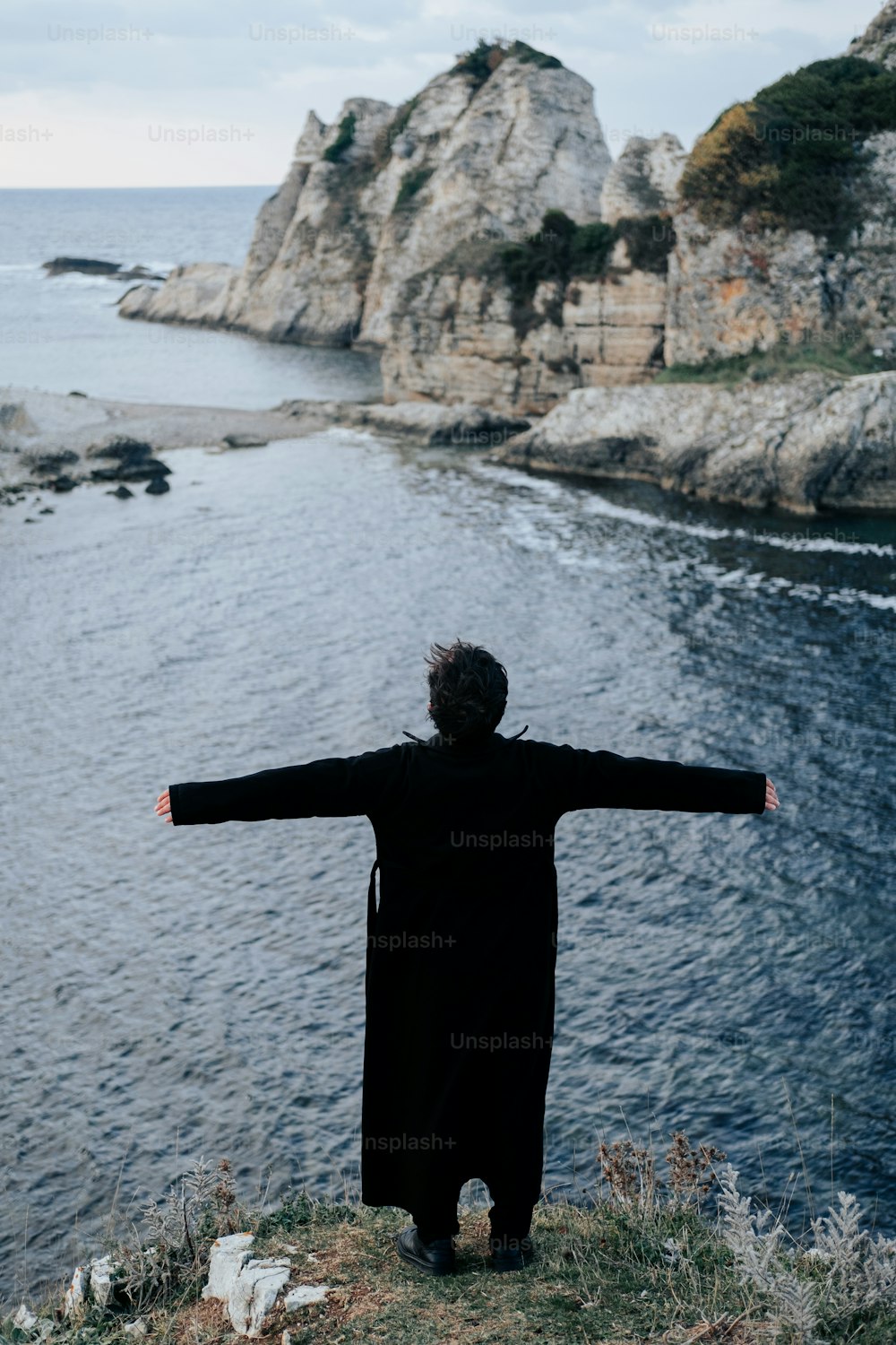 a person standing on a cliff overlooking a body of water