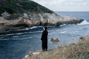 a man standing on a cliff overlooking the ocean