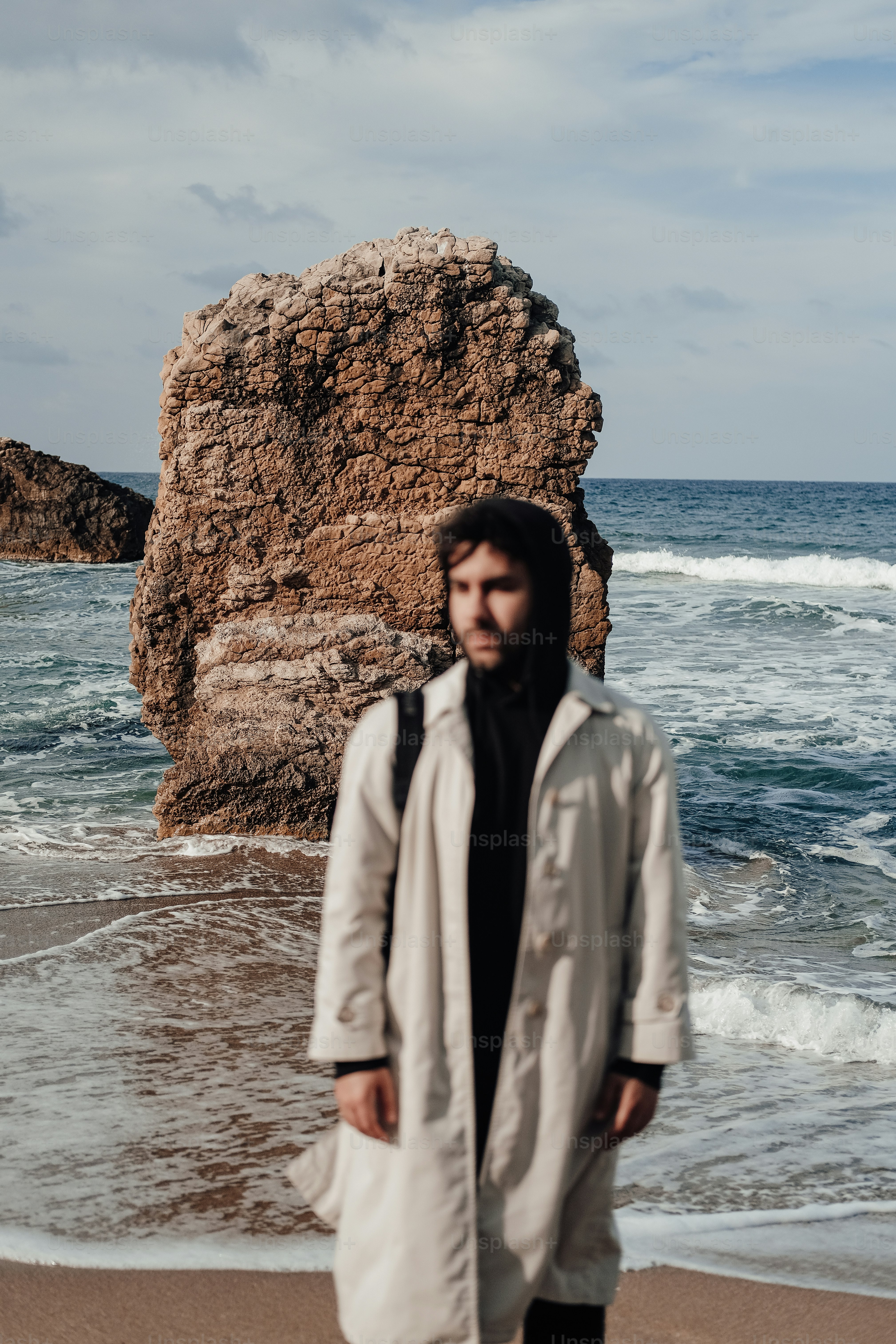 Un uomo in piedi su una spiaggia vicino all'oceano