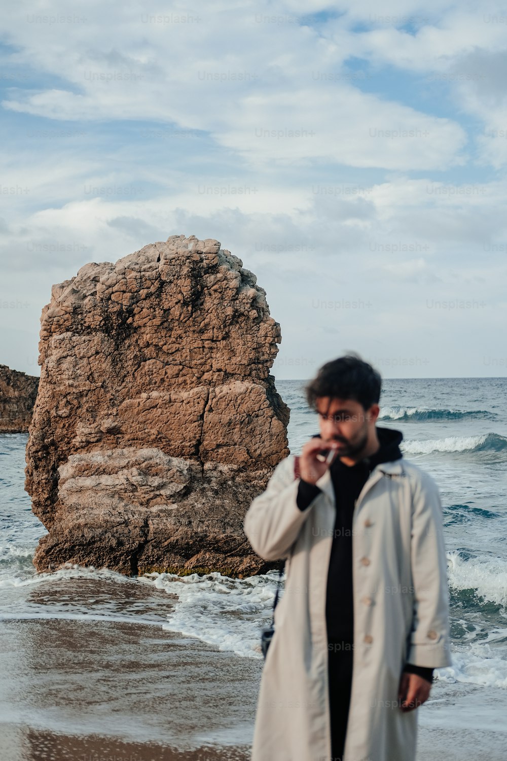 a man standing on a beach next to the ocean