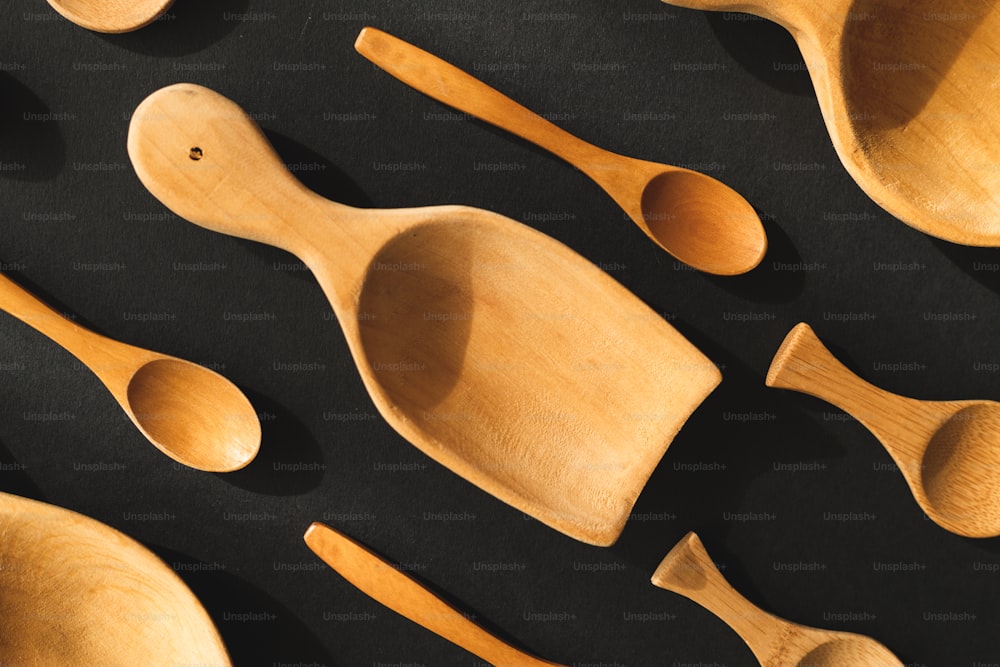 cucchiai di legno e cucchiaio poggiano su una superficie nera