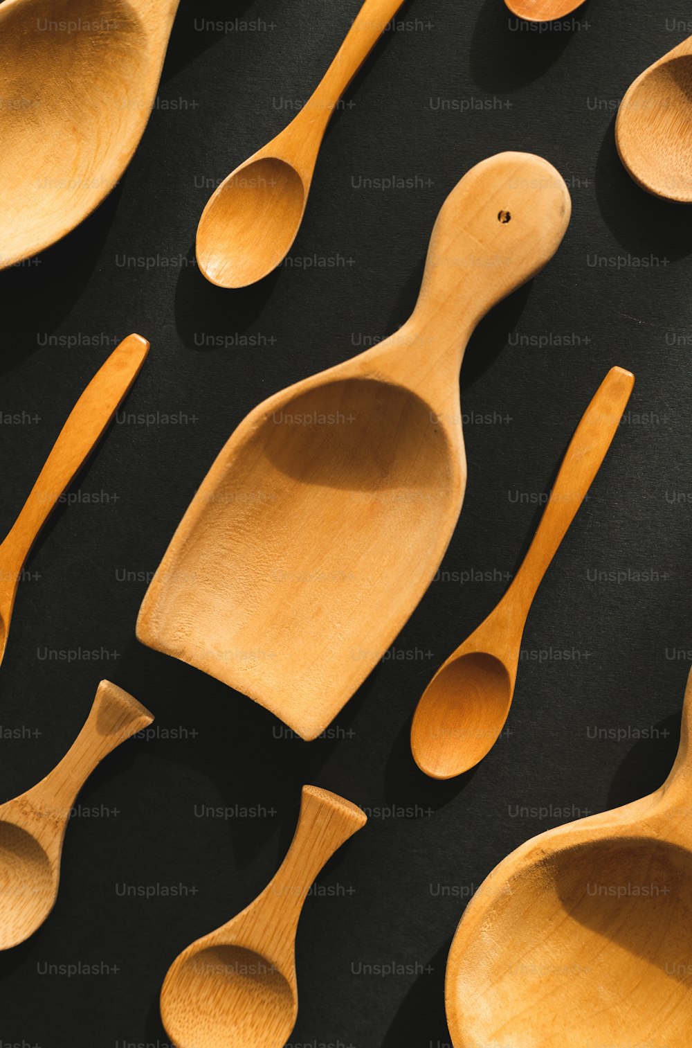 cucchiai di legno allineati su una superficie nera