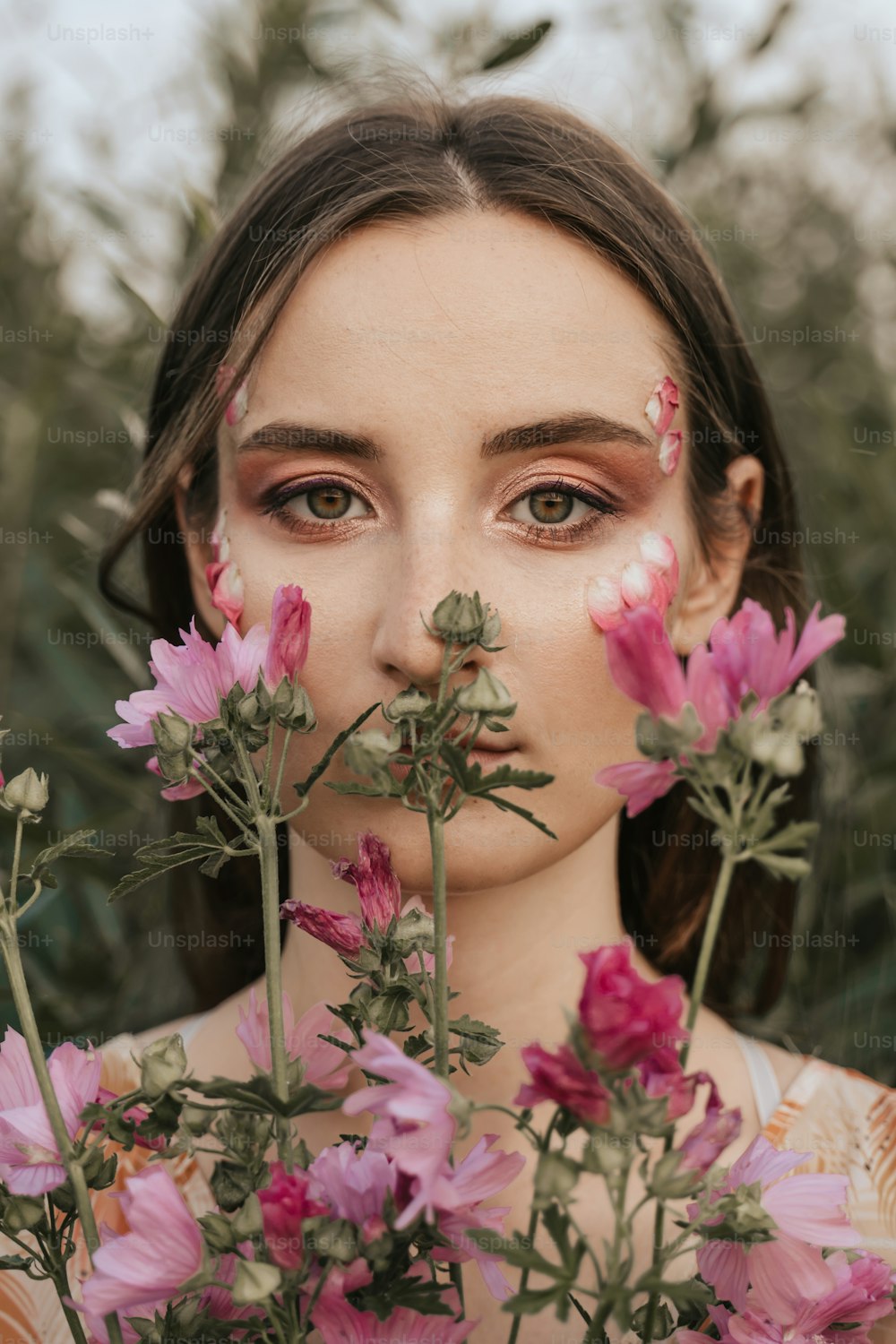uma mulher com flores ao redor do rosto