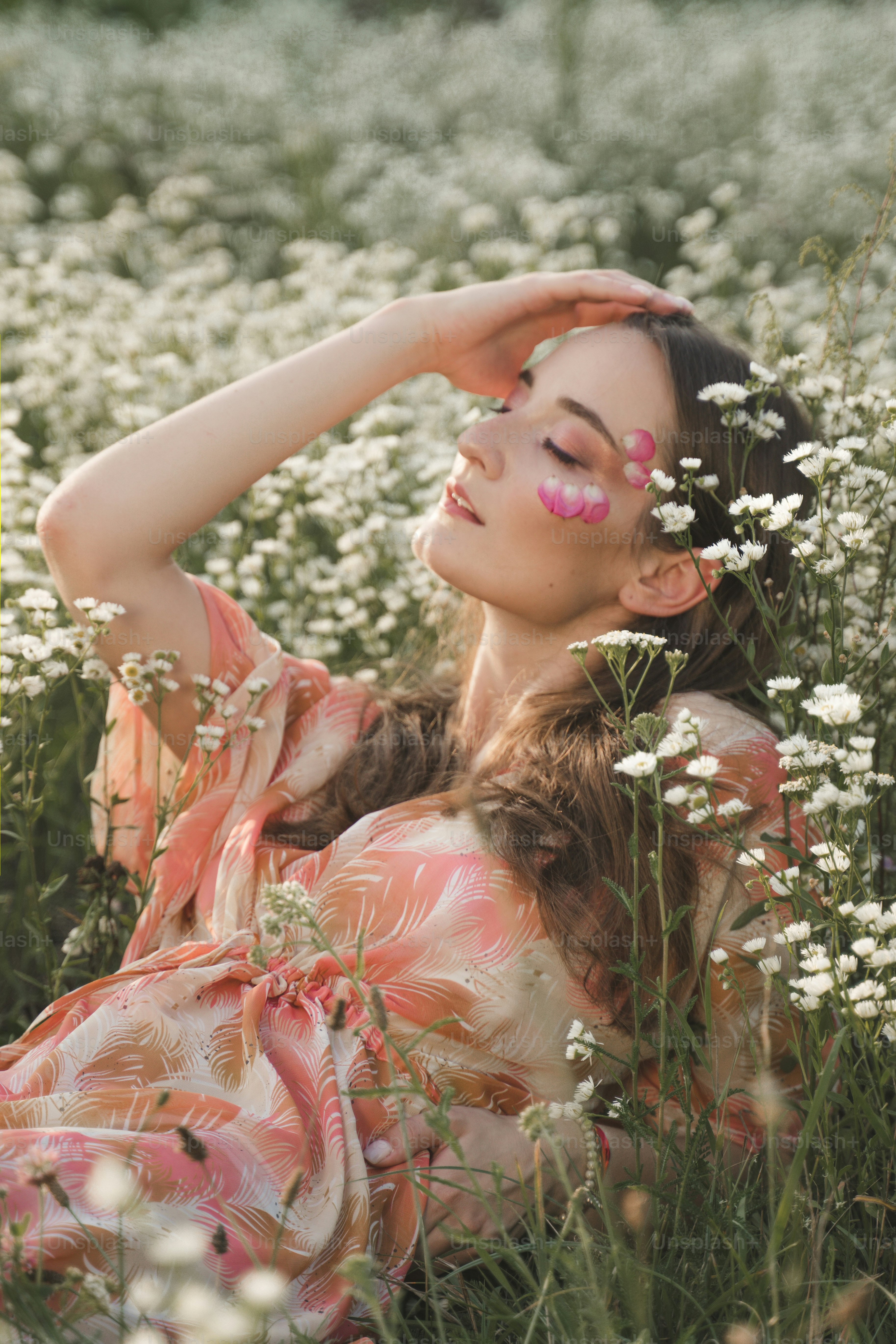 a woman laying in a field of white flowers